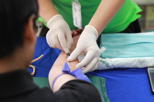 Medic takes blood from the arm of a patient